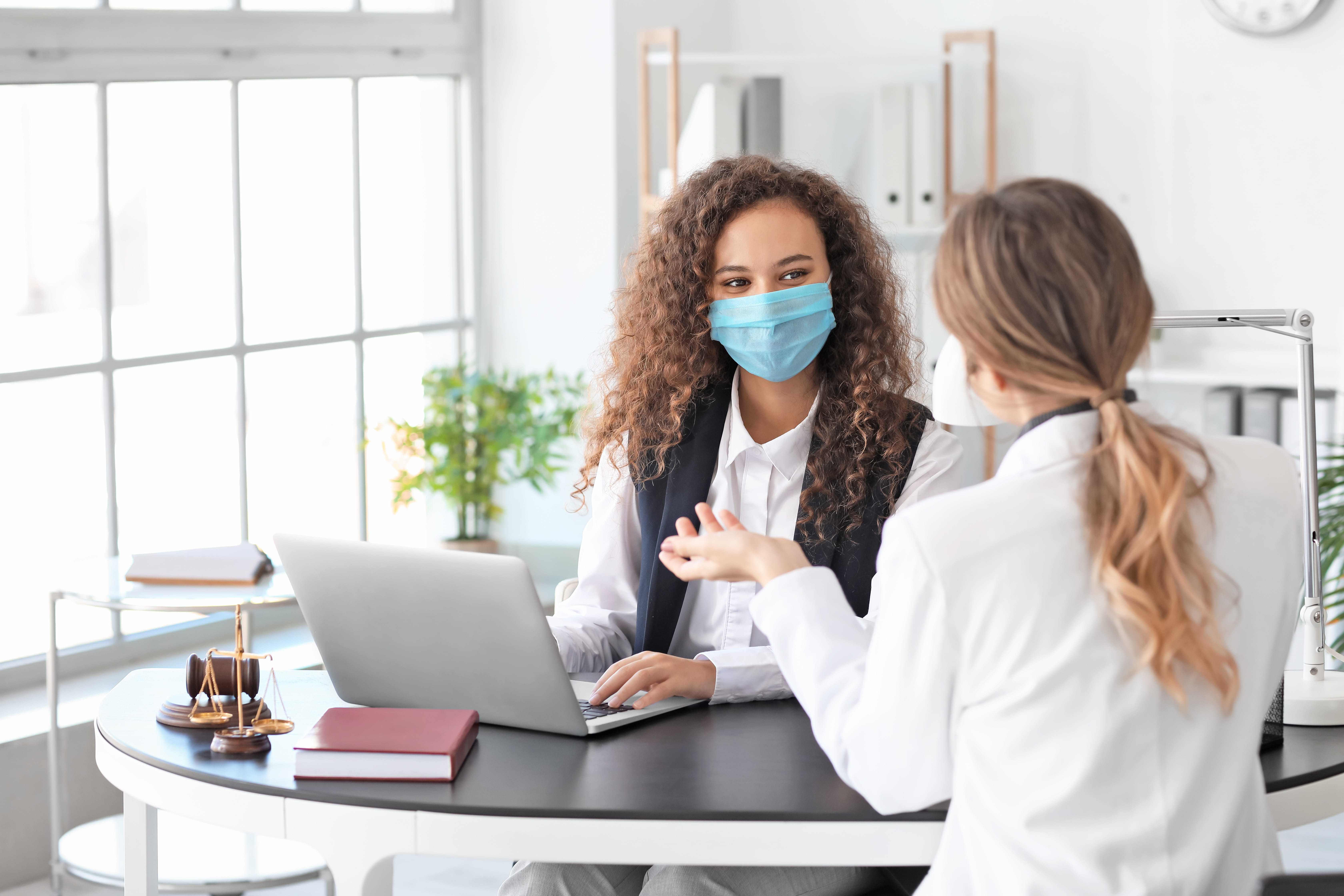 Medical staff wearing masks talking at laptop
