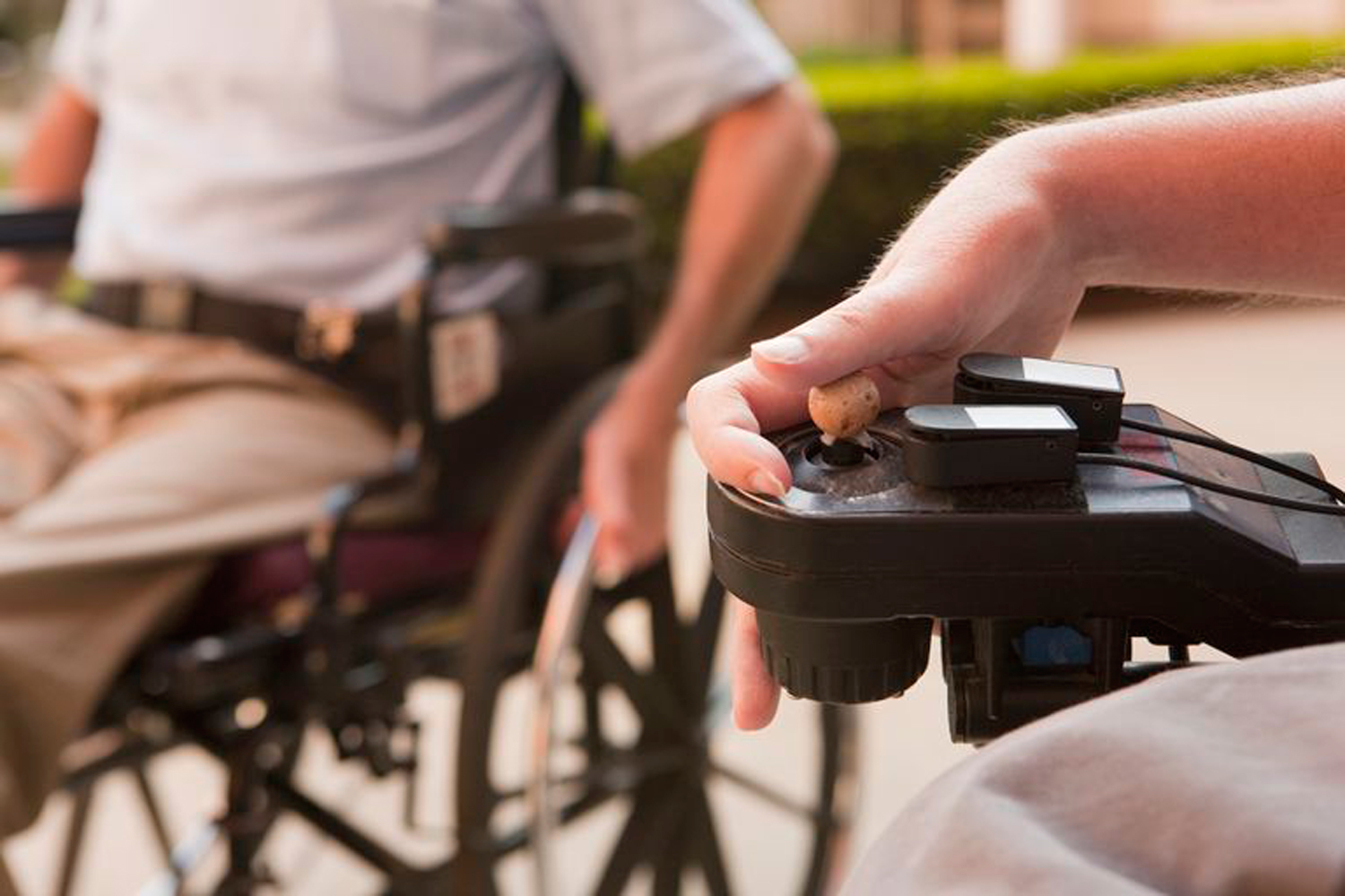 Young man's hand controlling motorized wheelchair