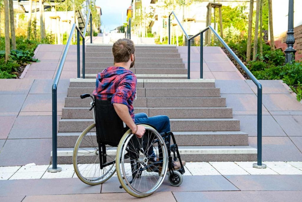 Man in wheelchair at foot of stairs