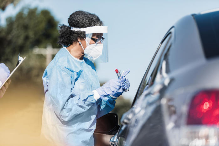 women wearing protective gear near a car window