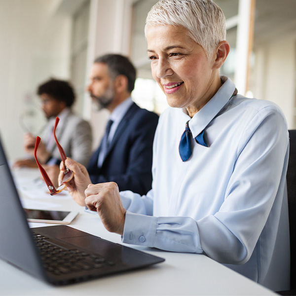 professional woman looking pleased while reviewing content on a laptop screen