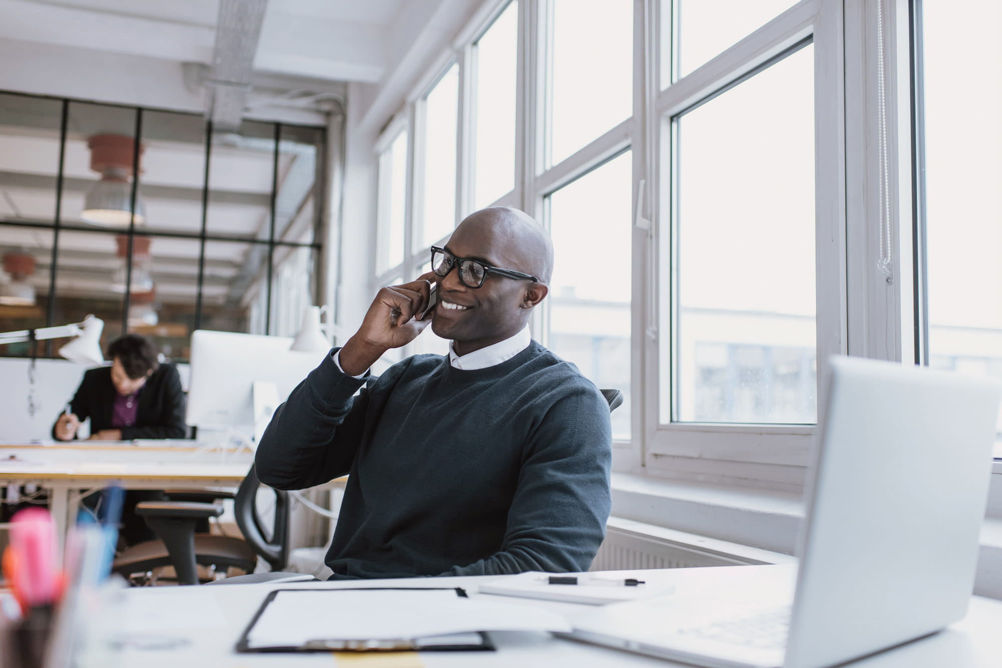 Man talking on mobile phone at a desk