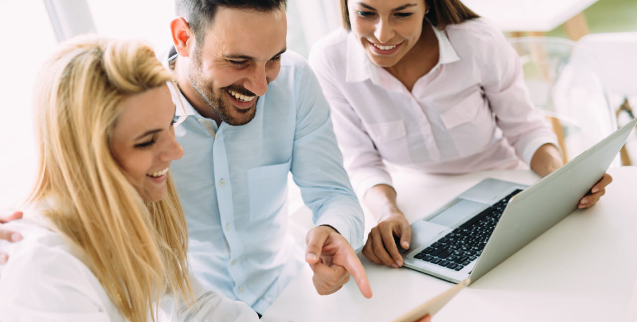 Group of smiling associates working on laptop